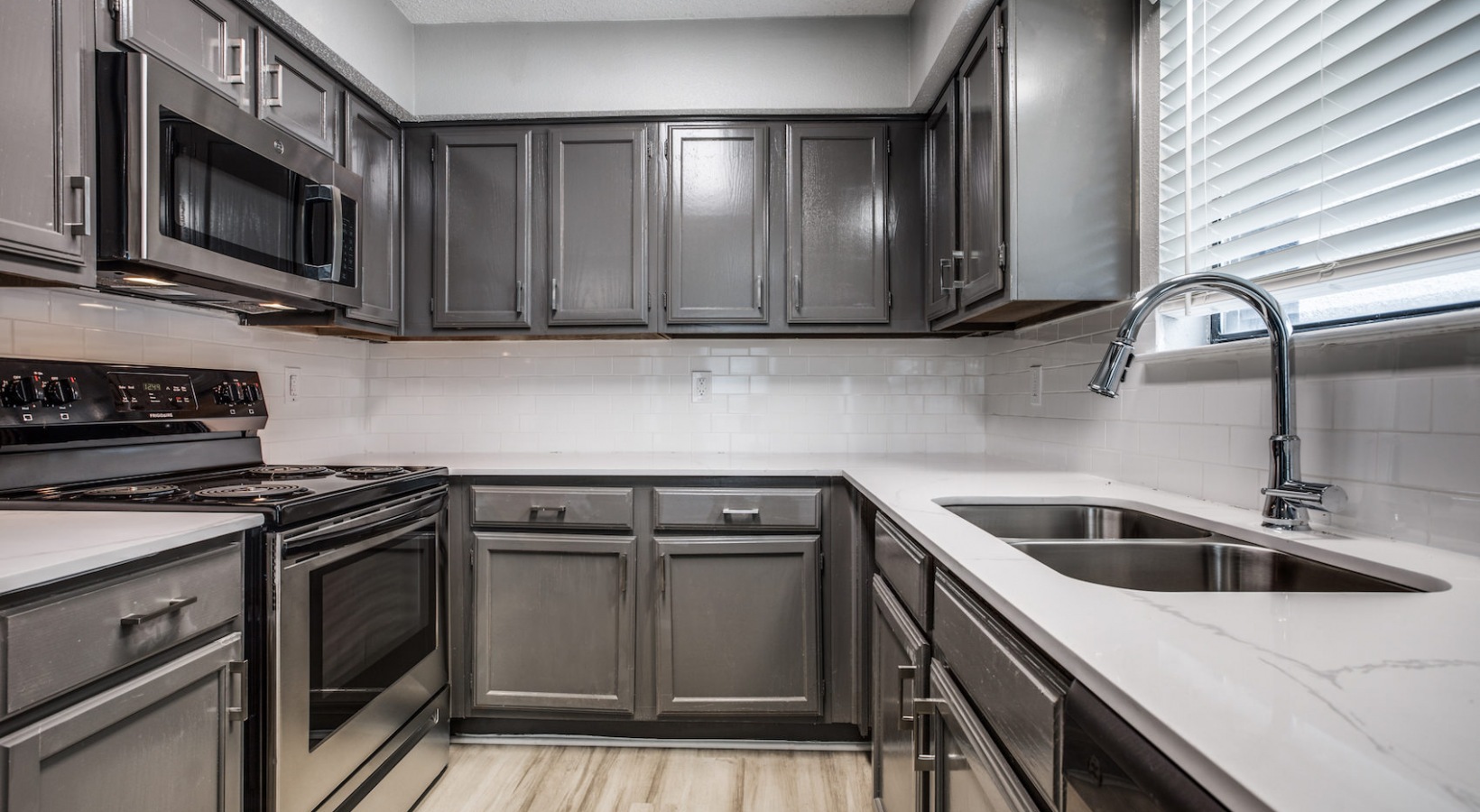 a kitchen with gray cabinets and stainless steel appliances at The  Republic East & West